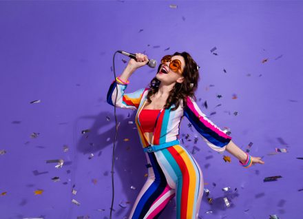 How To Release Music as a New Artist - Photo of dreamy pretty lady wear striped overall dark glasses singing discotheque songs isolated purple color background.