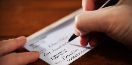 "Top Music Grants for Musicians & Indie Artists" Close up View of Hand Writing A Donation Check